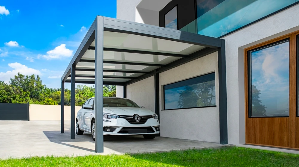 Carport moderne adossé à une maison contemporaine, abritant une Renault Mégane blanche