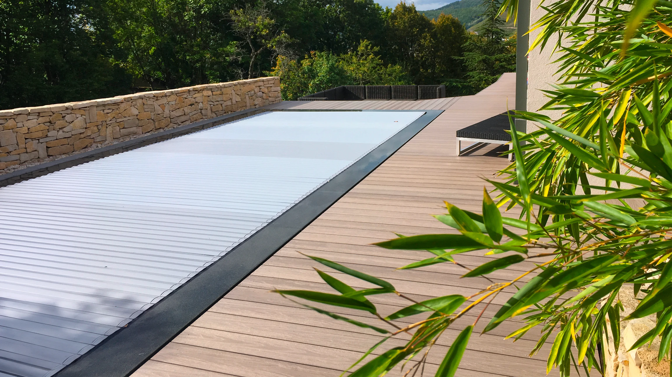 Terrasse extérieure résidentielle moderne avec salon de jardin gris sur deck en bois