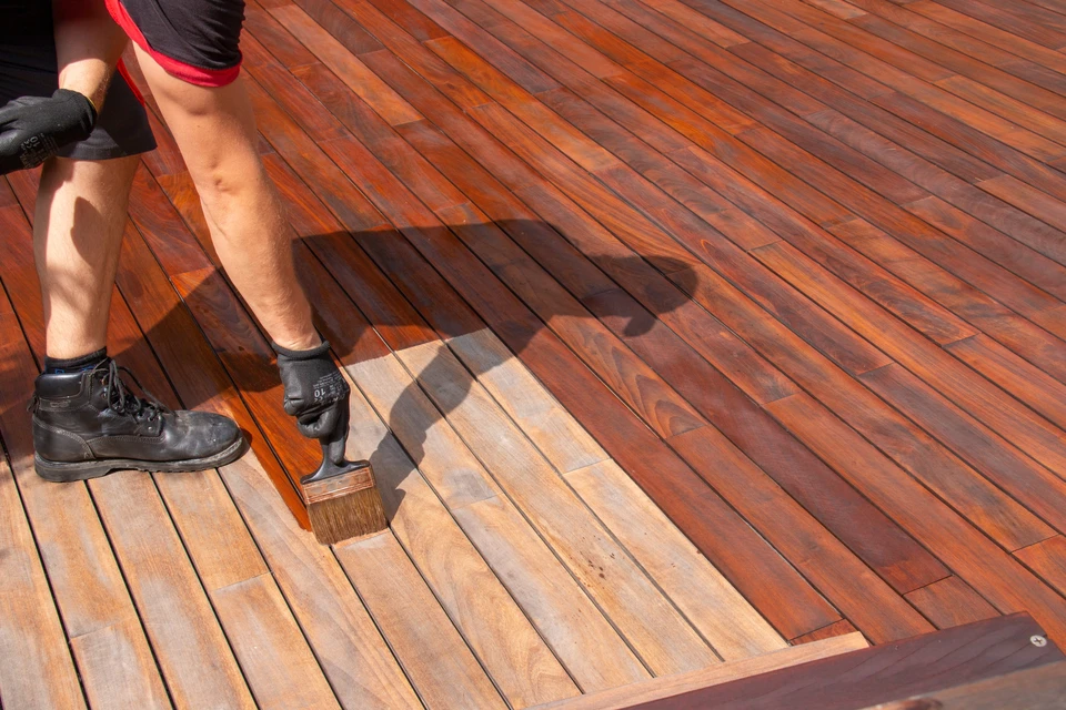 Chantier de construction extérieur avec ouvrier installant une terrasse en bois