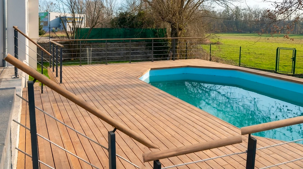 Piscine ronde enterrée sur terrasse extérieure surélevée, vue panoramique sur montagnes enneigées