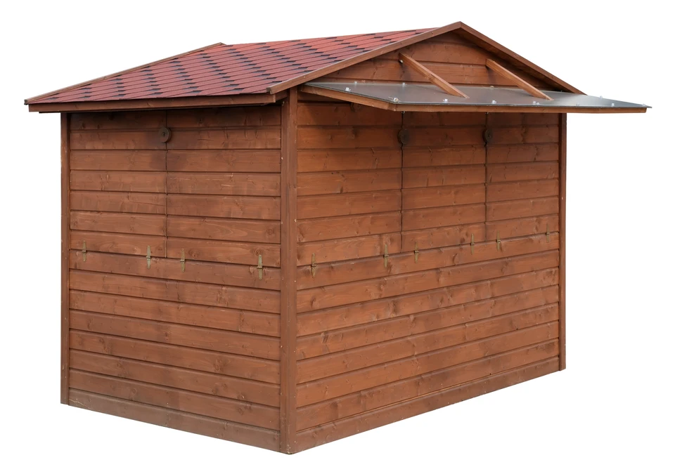 Scène extérieure rurale montrant une cabane moderne en bois installée sur terrain herbeux
