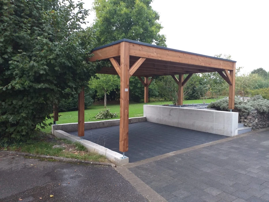Carport moderne adossé à une maison, abritant un SUV BMW X3 noir