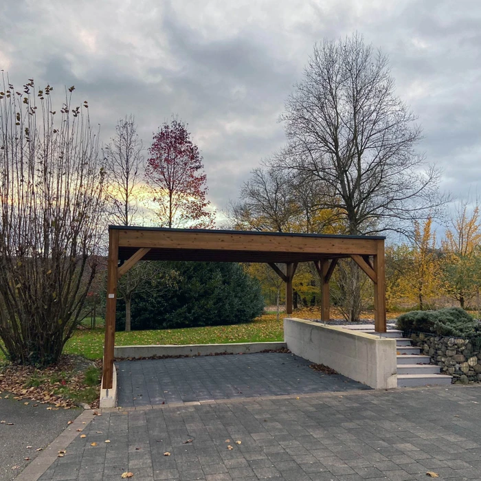 Terrasse extérieure moderne en dallage imitation bois, adjacente à une villa contemporaine à façade enduite claire