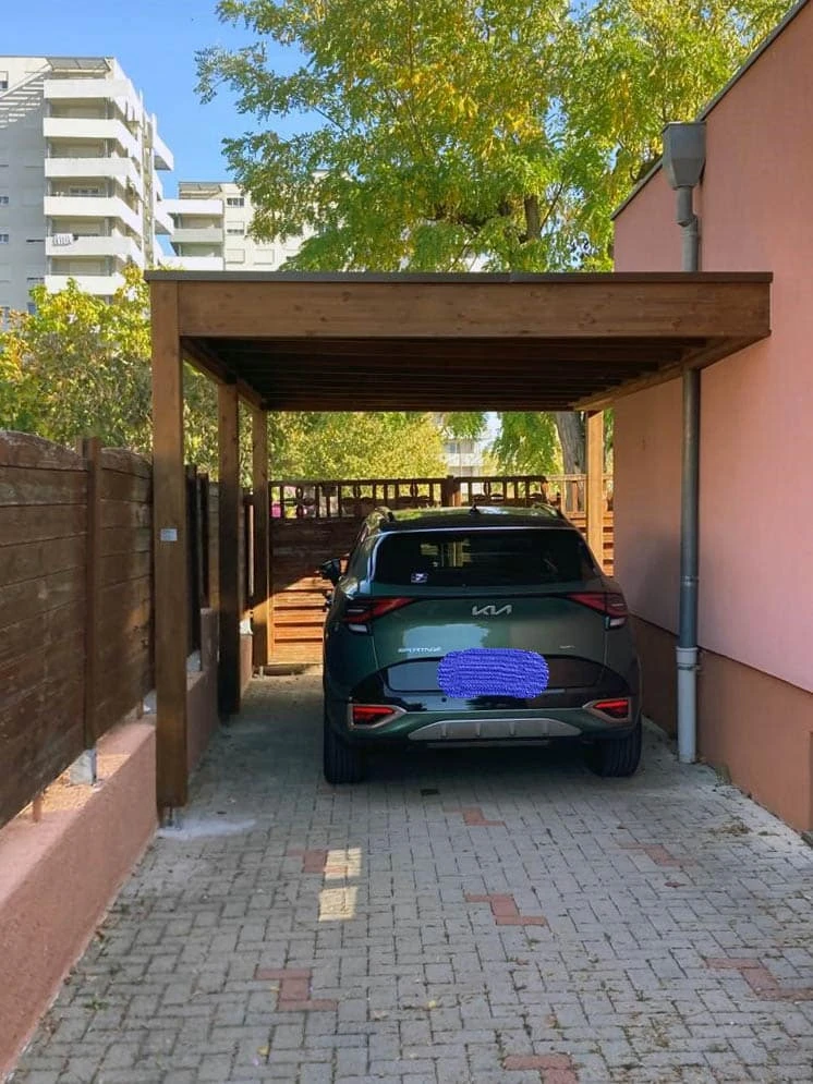 Carport moderne adossé à une maison, abritant un SUV BMW X3 noir