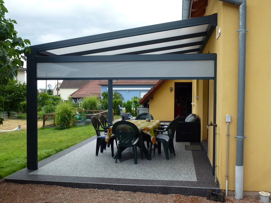 Terrasse extérieure avec mobilier de jardin en résine tressée naturelle : deux fauteuils daybed ovales et une table basse cylindrique