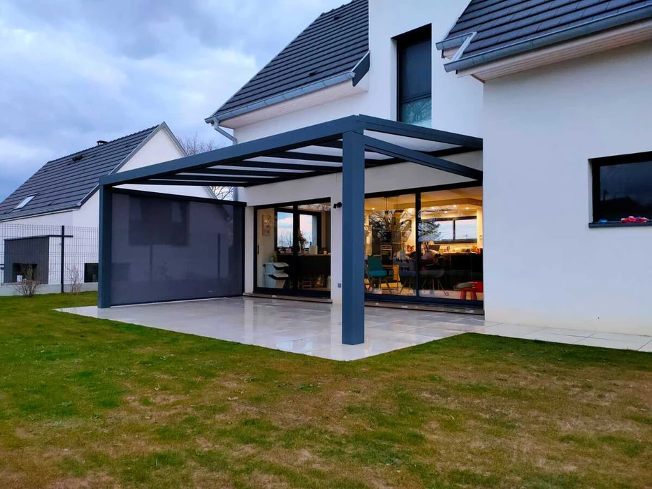 Terrasse extérieure avec mobilier de jardin en résine tressée naturelle : deux fauteuils daybed ovales et une table basse cylindrique