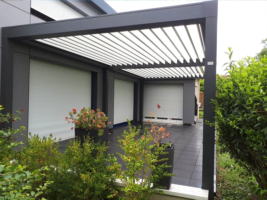 Terrasse extérieure avec mobilier de jardin en résine tressée naturelle : deux fauteuils daybed ovales et une table basse cylindrique