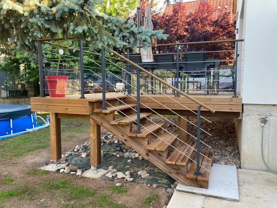 Terrasse surélevée en bois claire, fixée en façade arrière d'une maison contemporaine